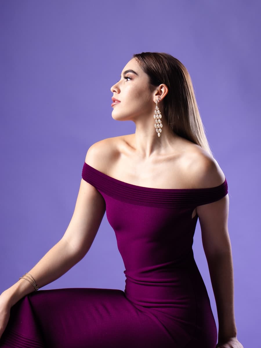 Model wearing a plum off-shoulder floor-length gown