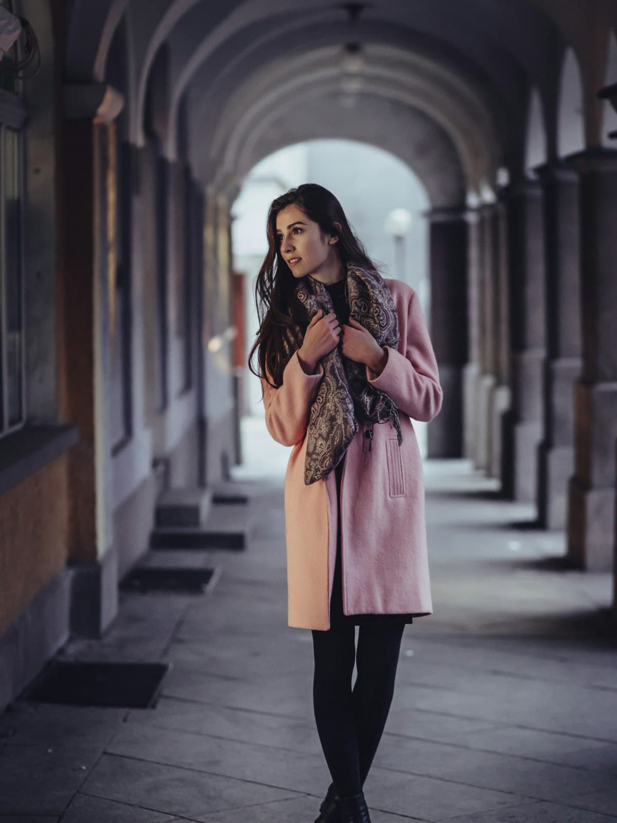 Model wearing a blush pink wool overcoat with a printed scarf