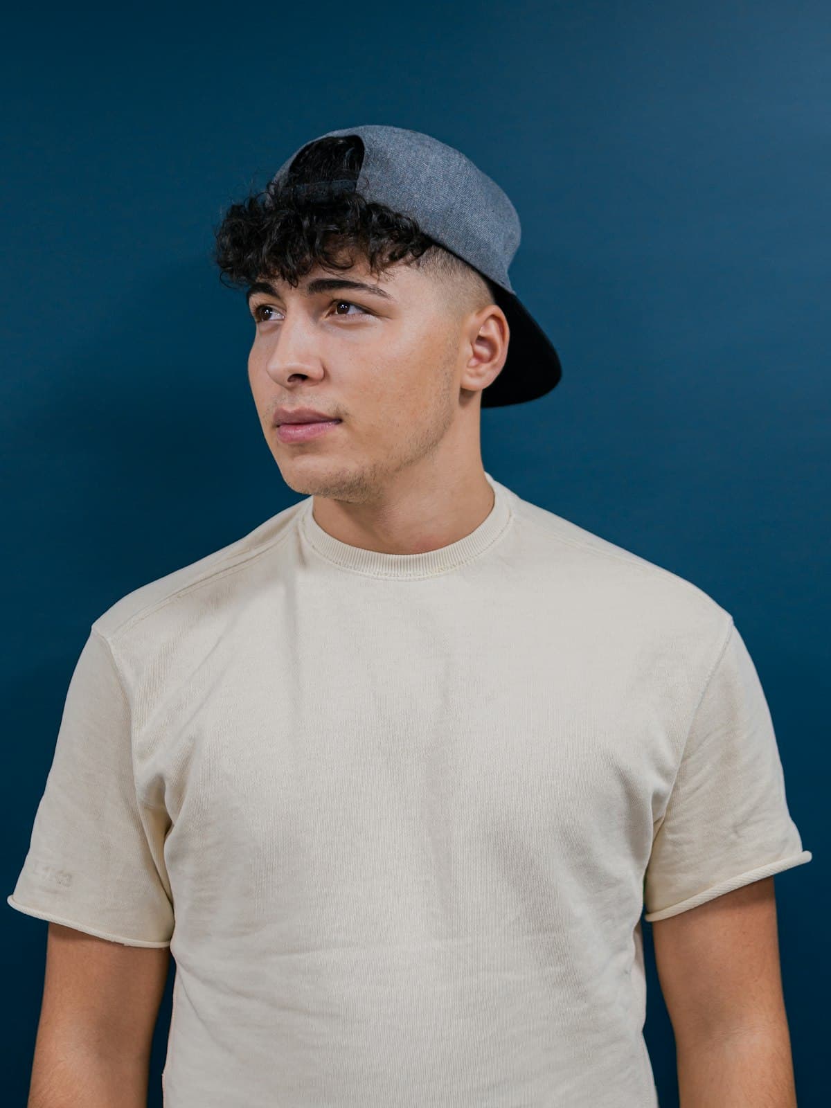 Model wearing an ecru heavyweight cotton tee against a navy backdrop