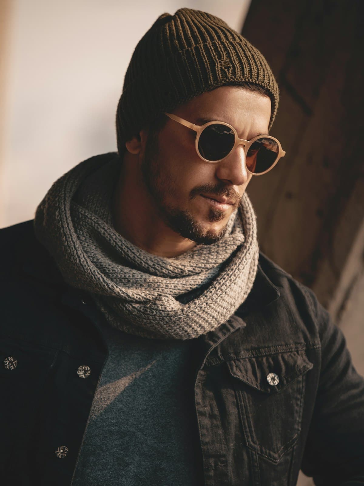 Model wearing a grey ribbed infinity scarf with a beanie and denim jacket