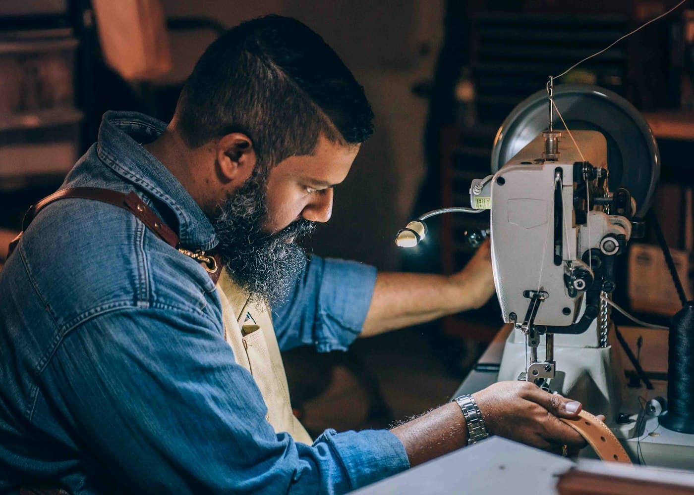 A tailor working at a sewing machine in a workshop
