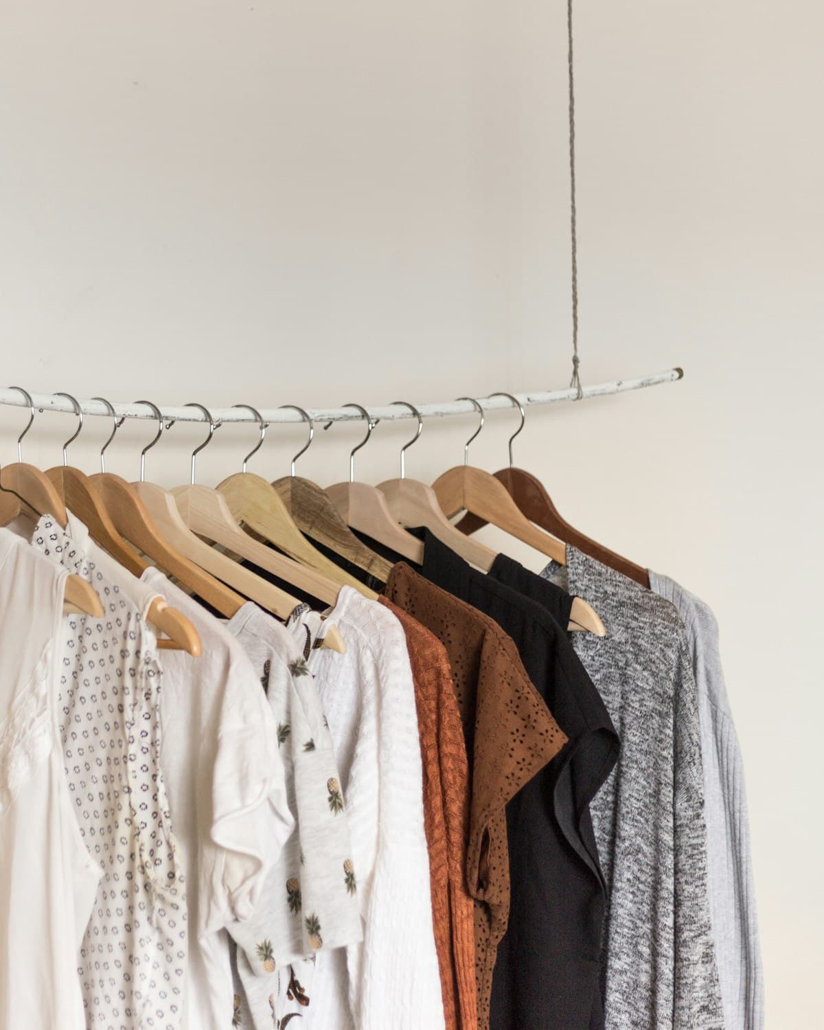 A rail of neutral-toned blouses and layered necklaces